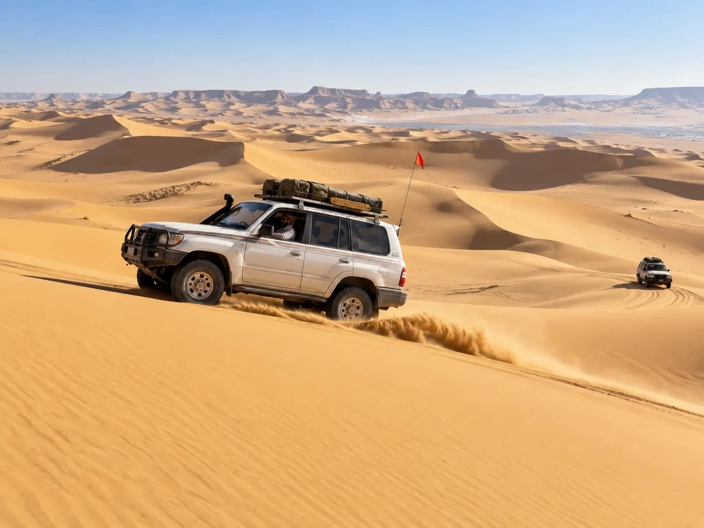 A 4×4 cresting a dune deep in the Sand Sea